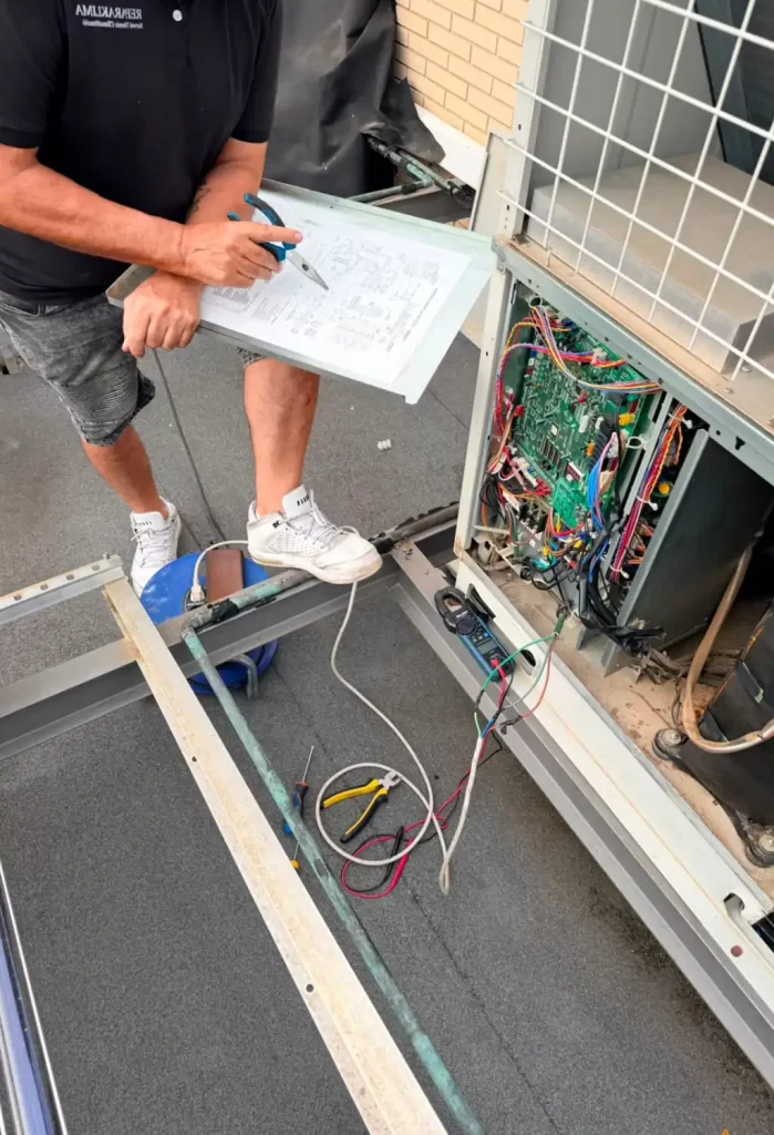 Tecnico de aire acondicionado inspeccionando unidad exterior de aire acondicionado